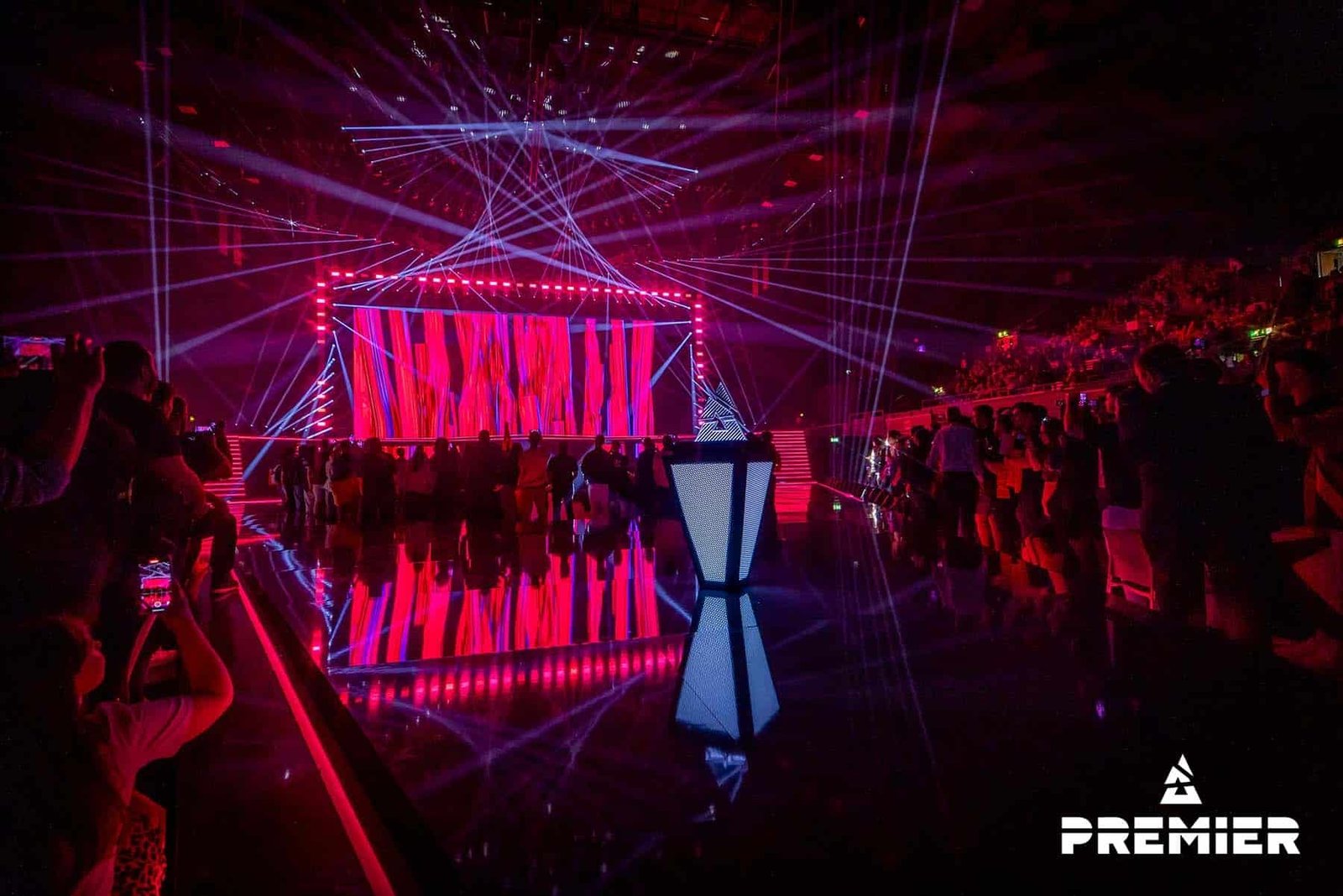 Image of BLAST Premier Spring Finals stage illuminated with red lights. In the foreground is the trophy awarded to the winners.